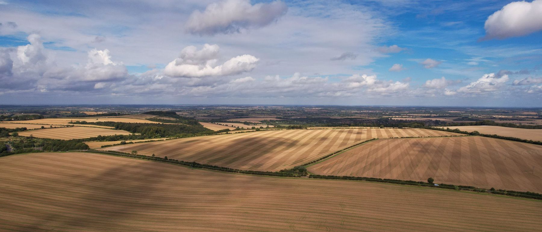 Aerial view of harvested arable fields running to the horizon