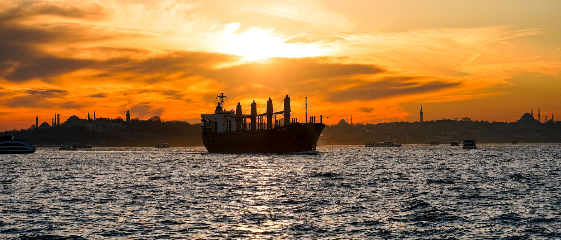 Cargo vessel on open water at sunset